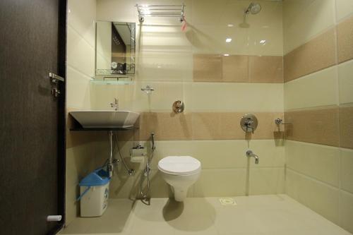 a bathroom with a toilet and a sink at Hotel Flair Inn in Ahmedabad