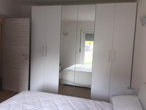 a bedroom with white cabinets and a mirror at Residenza Redipuglia in Bussolengo