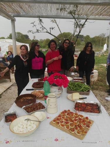 a group of women standing around a table with food at Borgo trulli 1789 in Ostuni