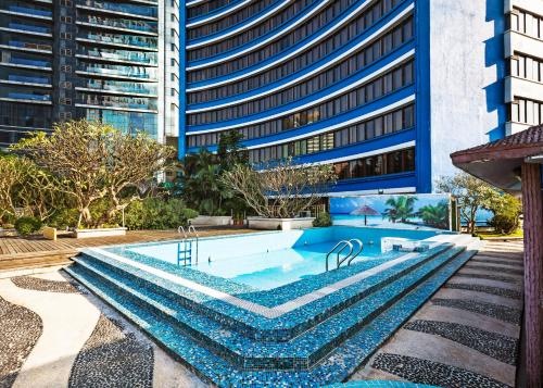 a swimming pool in front of a tall building at Ocean Hotel Guangzhou-Free Shuttle Bus to Canton Fair in Guangzhou