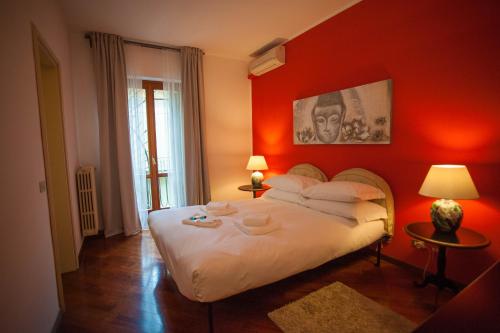 a bedroom with a large white bed with red walls at Italianflat - Via Mazzini in Verona