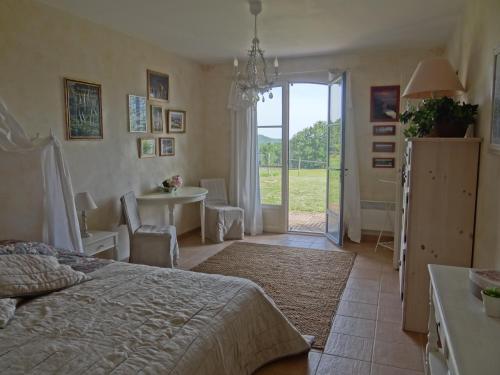 a bedroom with a bed and a desk and a table at La Rolandie Haute in Limeuil
