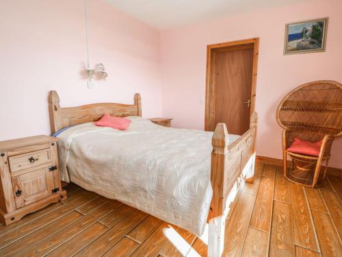 1 dormitorio con 1 cama y suelo de madera en Ocean Heights, en Coomhola Bridge