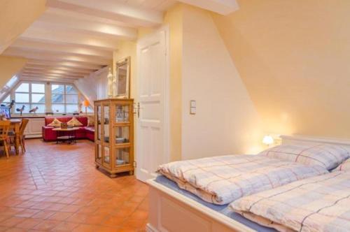 Un dormitorio con dos camas y una sala de estar. en Haus Seelord Whg. Smutje, en Braderup