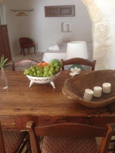 a wooden table with a bowl of fruit on it at Borgo trulli 1789 in Ostuni