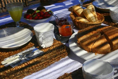- une table avec des assiettes et des paniers de pain et de boissons dans l'établissement La Rolandie Haute, à Limeuil