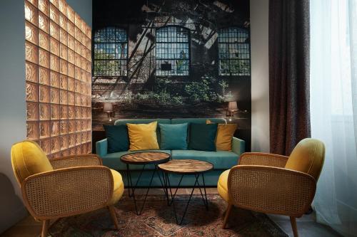 a living room with a blue couch and two tables at Hotel Verlaine in Cannes