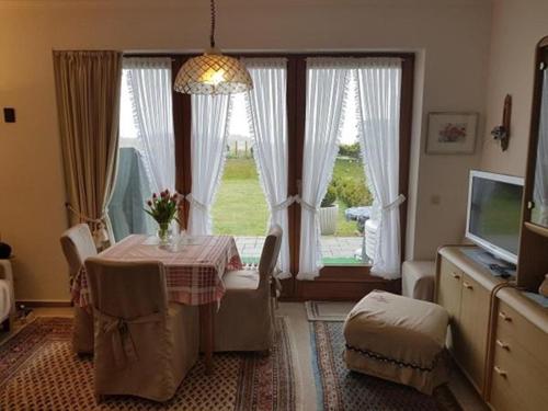 ein Esszimmer mit einem Tisch und einem Fenster in der Unterkunft Apartment Westerheide in Braderup