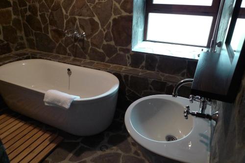 a bathroom with a tub and a sink and a window at Borislav's Farmhouse in Ogled