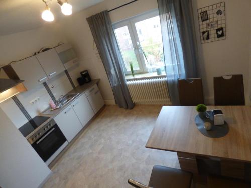 una pequeña cocina con mesa y un Sidx sidx sidx sidx en Apartmenthaus Geniusbank OL, en Wilhelmshaven