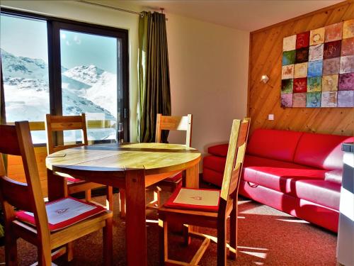 uma sala de estar com uma mesa e um sofá em Residence le Cime de Caron by PiaundDirk em Val Thorens