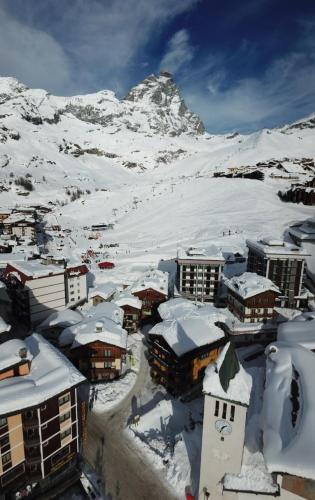 a city covered in snow with a mountain in the background at Hotel Meynet in Breuil-Cervinia