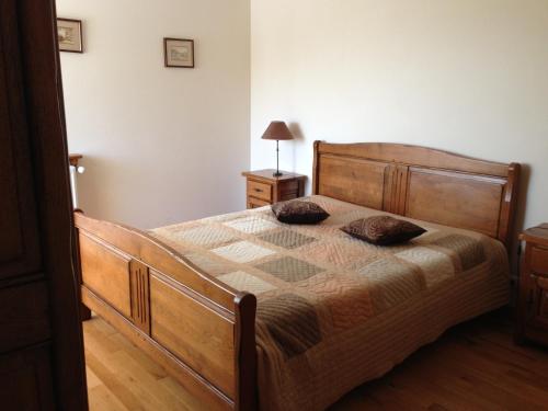 1 dormitorio con cama de madera y 2 almohadas en gite la Fraiseraie, en Flassigny