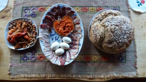 a table with a plate of food with eggs and bread at Guest House Glogovac in Kamenica