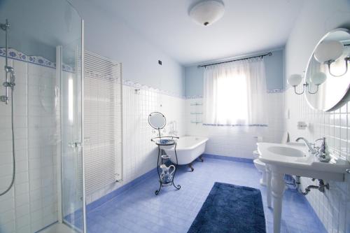 a white bathroom with a sink and a tub and a mirror at Agriturismo Gazza Ladra in Noventa di Piave