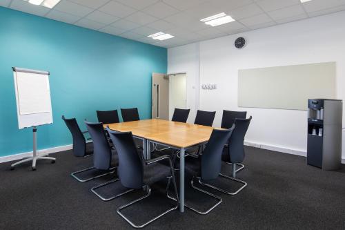 a conference room with a wooden table and chairs at Warwick Conferences - Radcliffe in Coventry