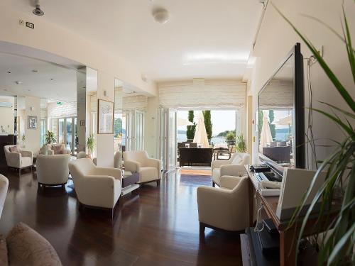 a waiting room with white chairs and a television at Hotel Bozica Dubrovnik Islands in Suđurađ