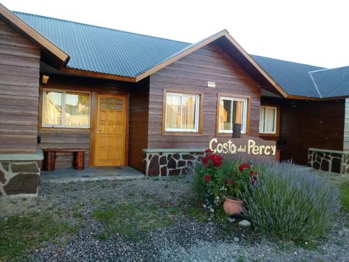a log cabin with a yellow door and a porch at Cabañas Costa del Percy in Trevelin