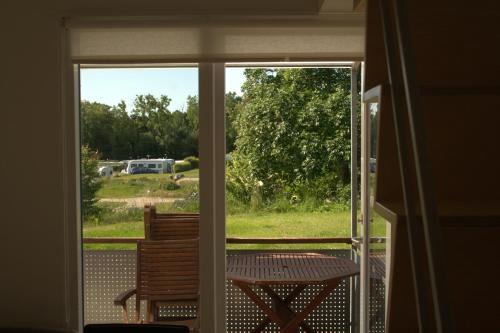 an open door to a patio with a chair outside at Sorø Camping & Cottages in Sorø