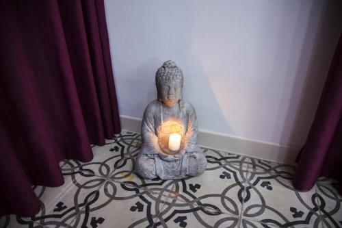a statue sitting on a floor with a candle at VILLA ADELAIDE SUITE & ROOM in Torre a Mare
