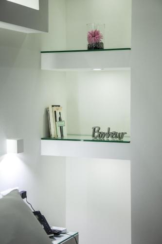 a white room with a bed and a shelf on the wall at VILLA ADELAIDE SUITE & ROOM in Torre a Mare