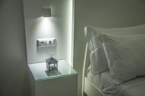 a side table with a lamp next to a bed at VILLA ADELAIDE SUITE & ROOM in Torre a Mare