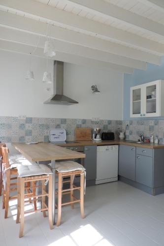 une cuisine avec une table et des chaises en bois dans l'établissement Belval Cottages, à Bénouville