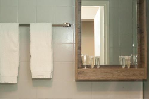 a bathroom with a mirror and white towels at Hotel de Hoeve van Nunspeet in Nunspeet