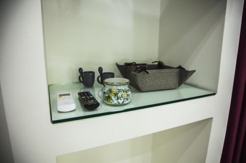a glass shelf on a wall with a remote control at VILLA ADELAIDE SUITE & ROOM in Torre a Mare