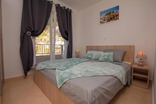 Un dormitorio con una cama grande y una ventana en Robinson Bella, en Bogomolje