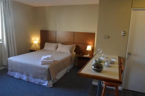 a bedroom with a bed and a table with two lamps at Origen Apart-Hotel in Santiago