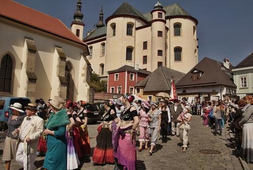a large group of people walking down a street at Penzion V Podzámčí Litomyšl in Litomyšl