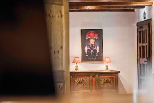 a painting of a man in a hat on a wall at Kaisers Tanne - Premium Alles Inklusive Hotel in Breitnau