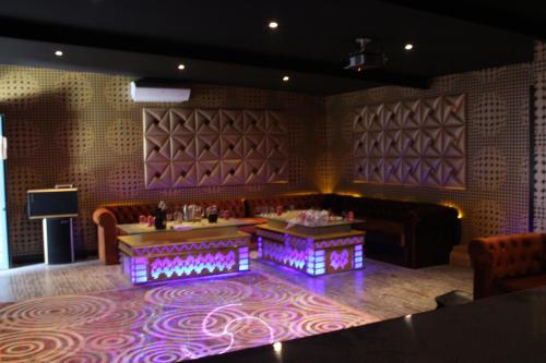 a room with a couch and a table with purple lights at Hotel Sierra Oriente in Guadarrama