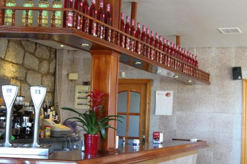 a bar with red wine bottles on a shelf at Hotel Sierra Oriente in Guadarrama