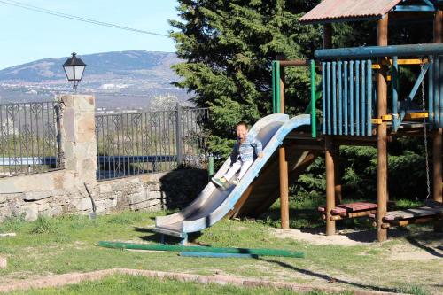 a boy on a slide at a playground at Hotel Sierra Oriente in Guadarrama