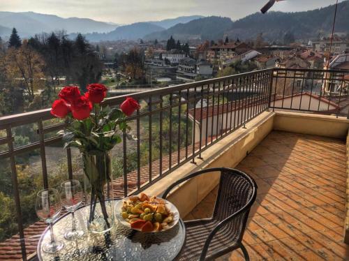 a table with a vase of flowers on a balcony at Troyan Plaza Hotel in Troyan