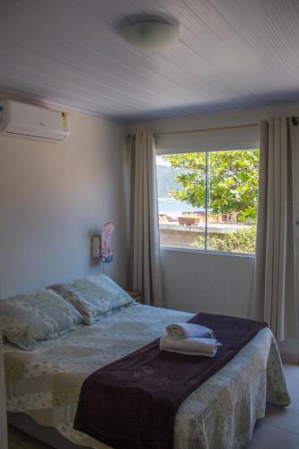 a bedroom with a bed and a large window at Pousada Estrelas no Mar Florianópolis in Florianópolis