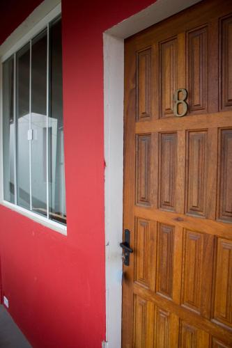 a wooden door with the number eight next to a window at Pousada Estrelas no Mar Florianópolis in Florianópolis