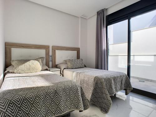 RodaにあるOlivar de Roda Golf - Villa - 1409のベッドルーム1室(ベッド2台、窓付)