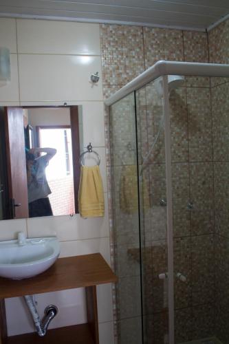 a bathroom with a shower and a sink and a mirror at Pousada Estrelas no Mar Florianópolis in Florianópolis
