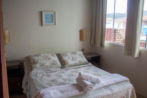a bedroom with a bed with a towel on it at Pousada Estrelas no Mar Florianópolis in Florianópolis