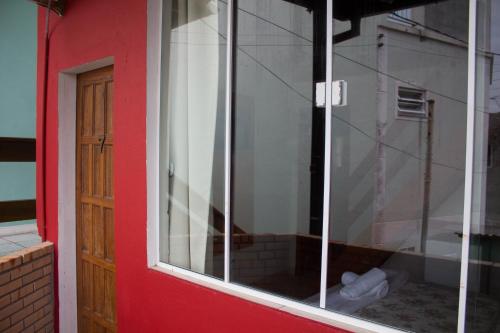 a window of a building with a red door at Pousada Estrelas no Mar Florianópolis in Florianópolis