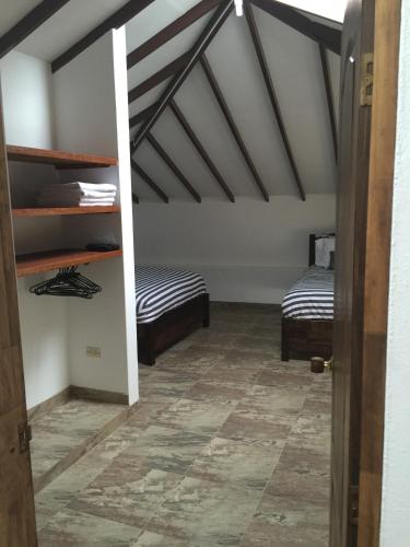 a room with two beds in a attic at Villa Pepita Real in Villa de Leyva