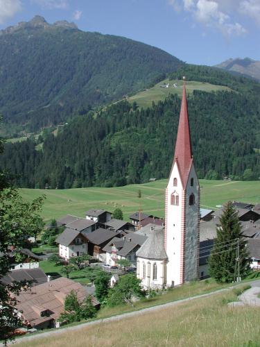 a small white church with a steeple on a hill at Gästehaus Ortner in Liesing