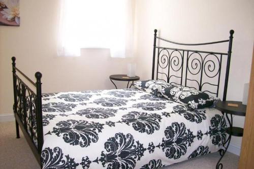 a bedroom with a black and white bed with pillows at Contemporary Cottage Holidays in Bridlington