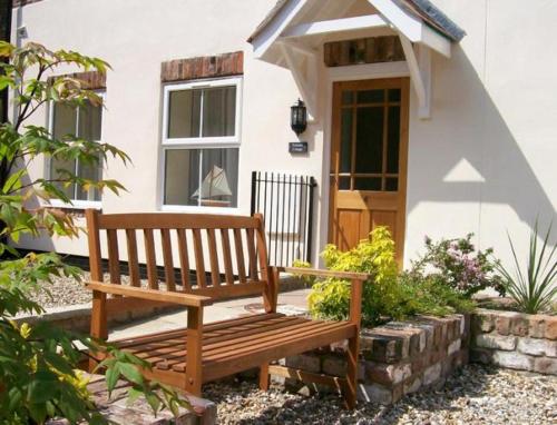a wooden bench sitting in front of a house at Contemporary Cottage Holidays in Bridlington
