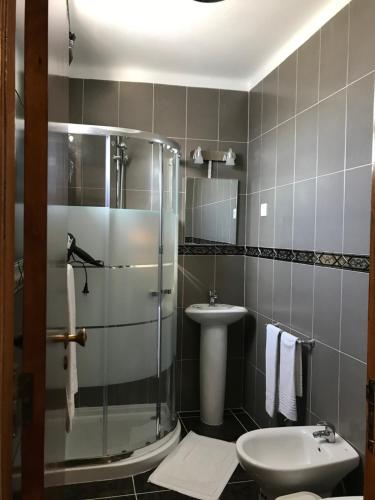 a bathroom with a shower and a toilet and a sink at Hostel Boutique Marisol in Monte Gordo