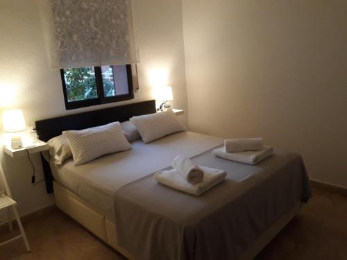 1 dormitorio con 1 cama con 2 toallas en Miramar Habitaciones en Calabardina
