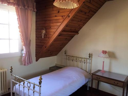 - une chambre avec un lit blanc et un plafond en bois dans l'établissement MAISON EMILIE, à Le Touquet-Paris-Plage